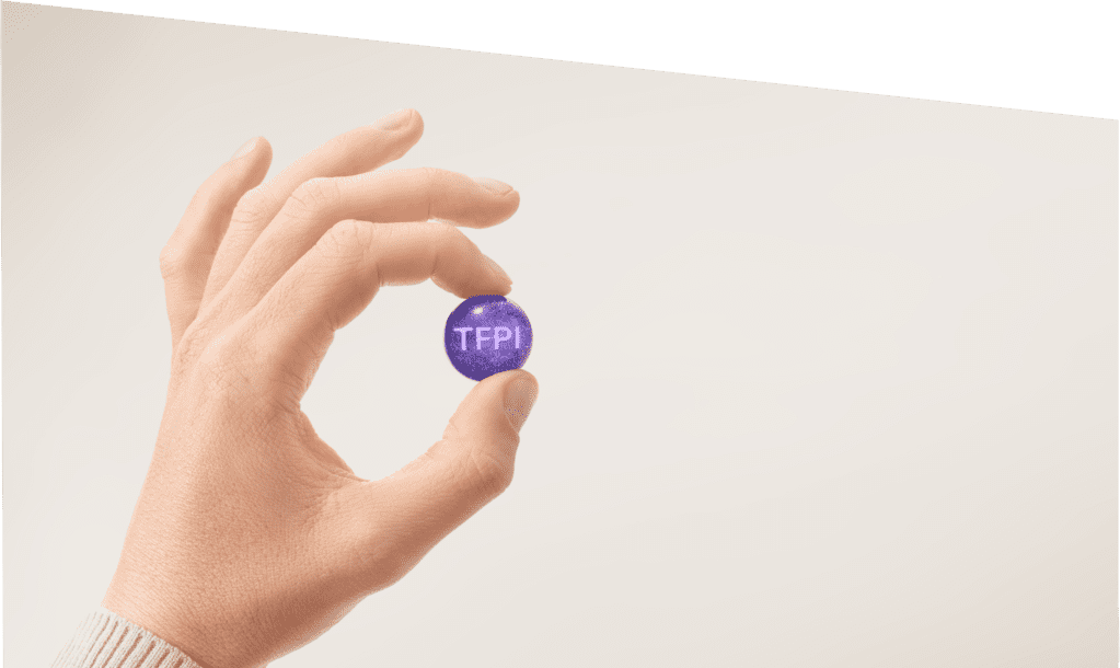 A hand holding a small purple ball representing TFPI